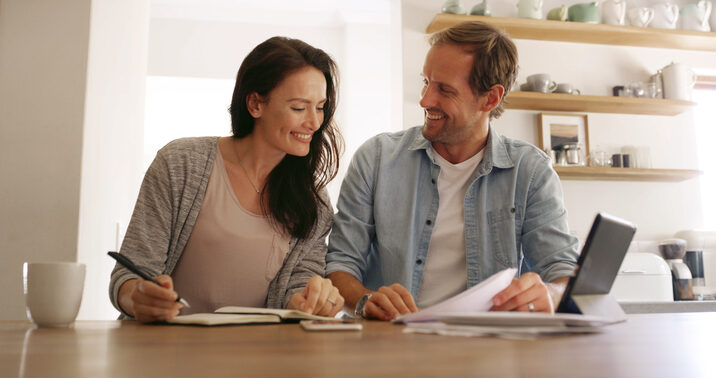A couple reviewing heat pump rebate savings at their kitchen table